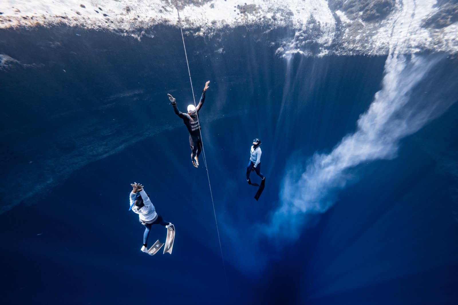 Freedivers rising up the line from the deep at Dean's Blue Hole, Bahamas, during Vertical Blue 2025
