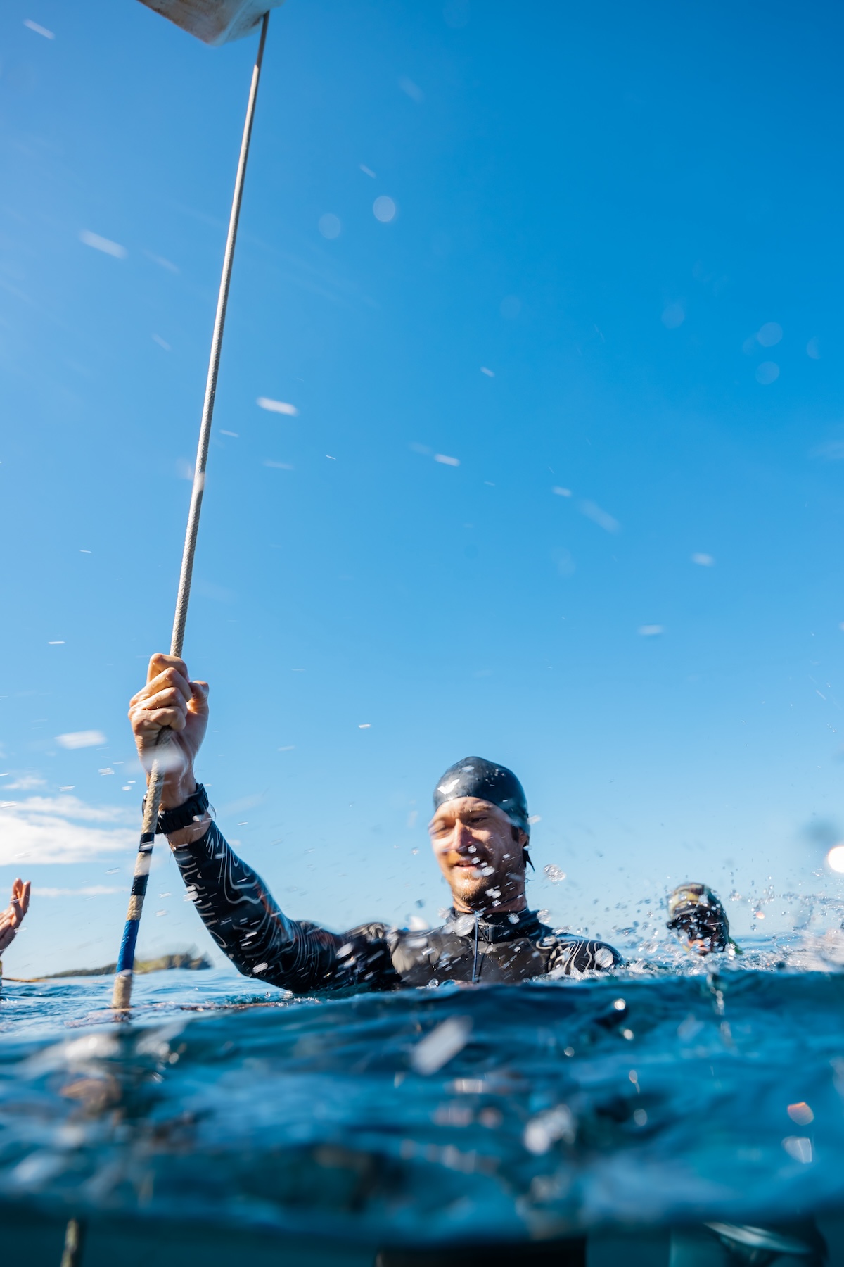 A freediver celebrating a successful competition dive at the surface