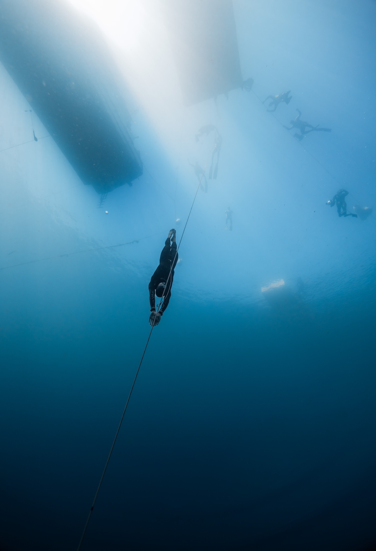 Freediver descending into clear Caribbean blue with no fins