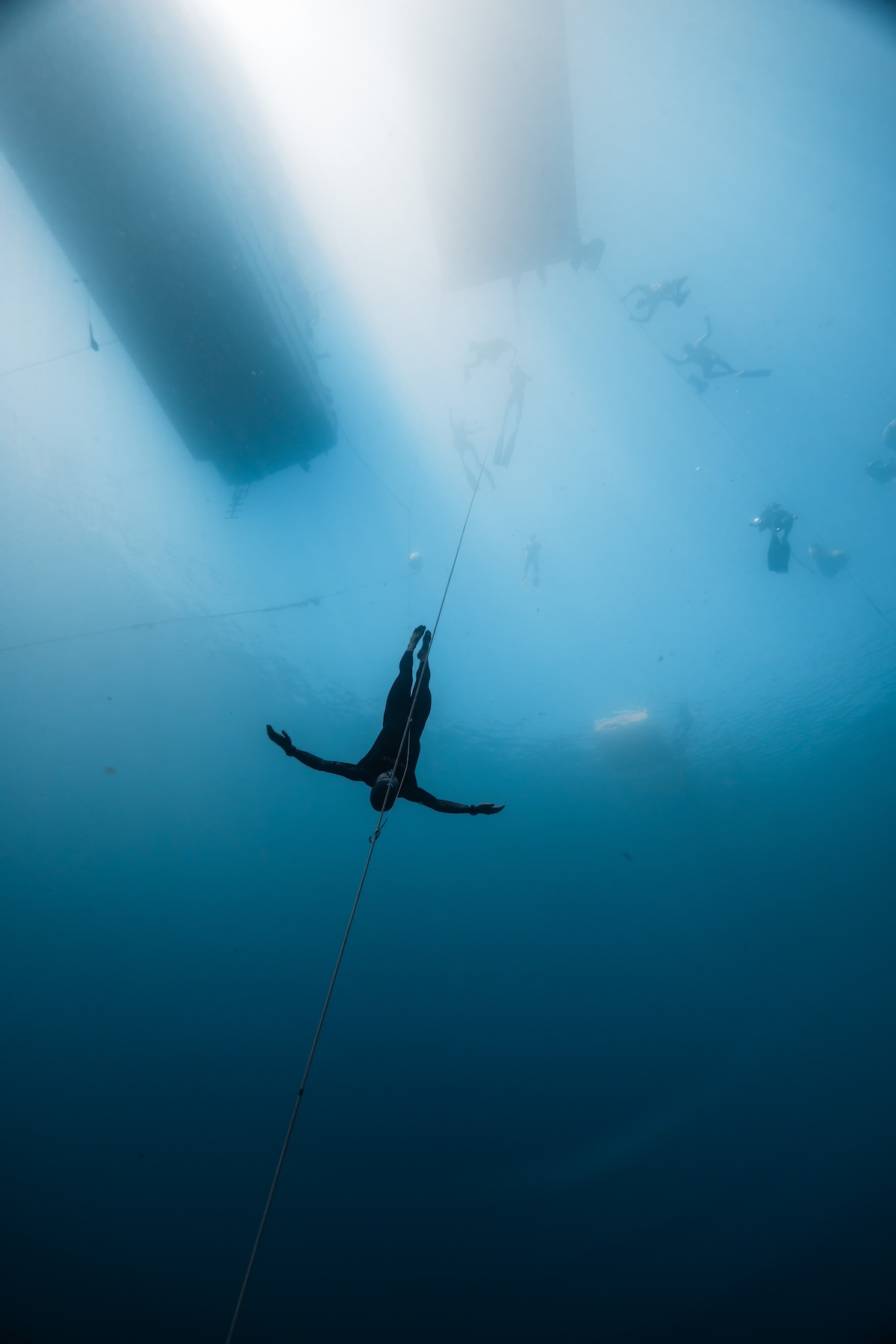 A relaxed no-fins freediver deep on the line