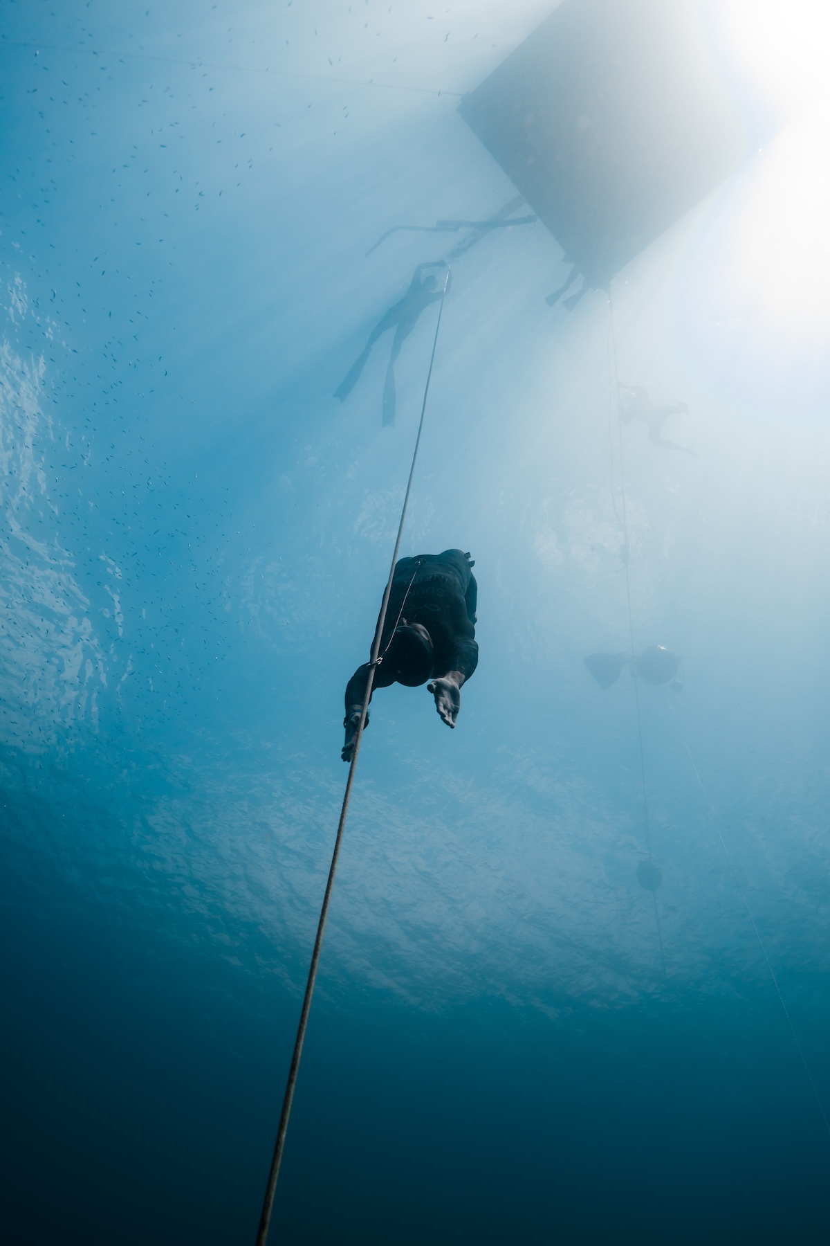 A freediver descending into the blue