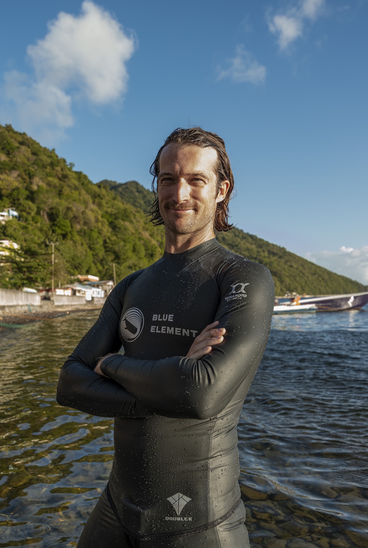 Harry McCahill in a wetsuit on the shore of Soufrière Bay, Dominica